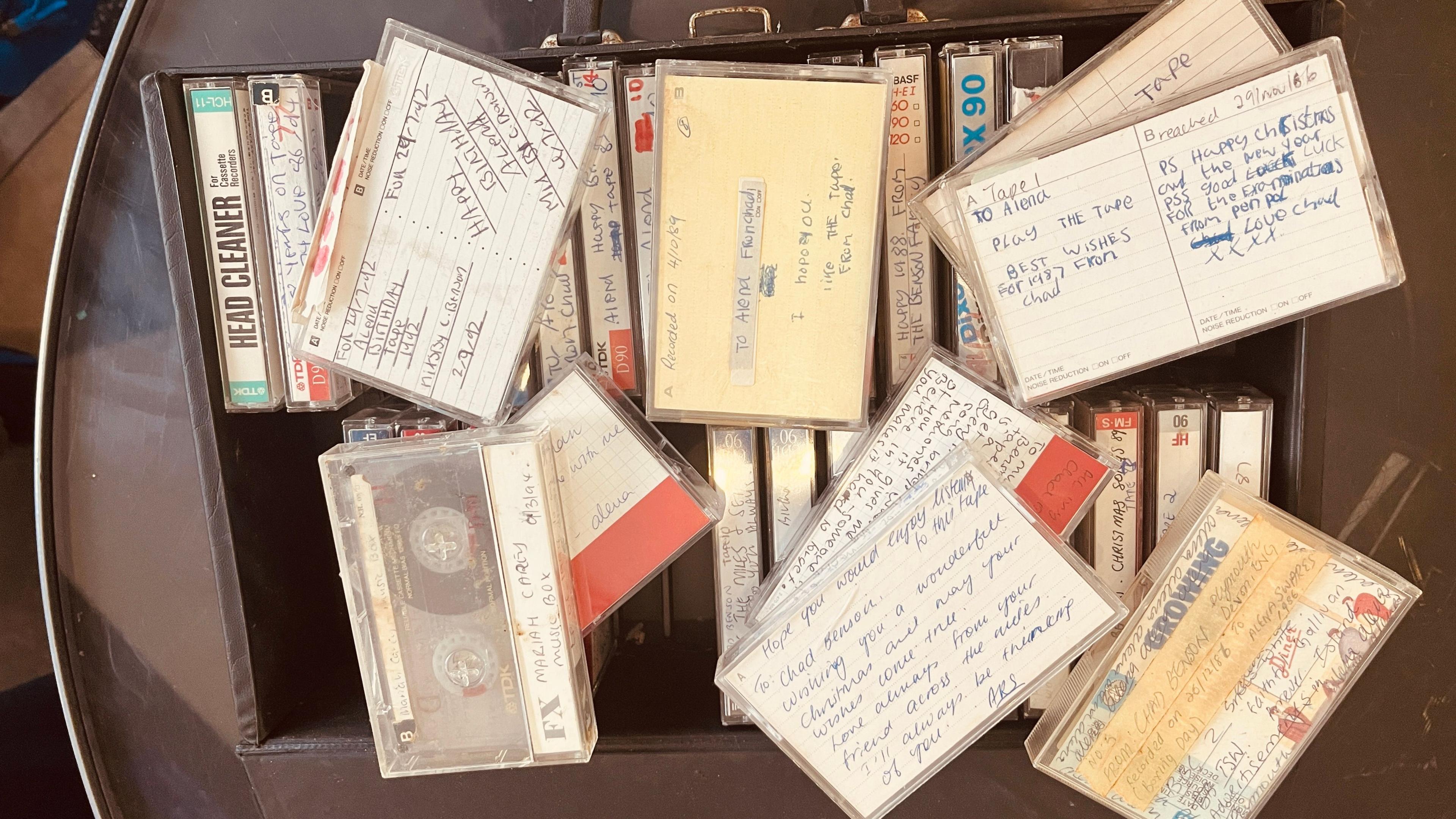 A box of cassette tapes with writing on the covers.