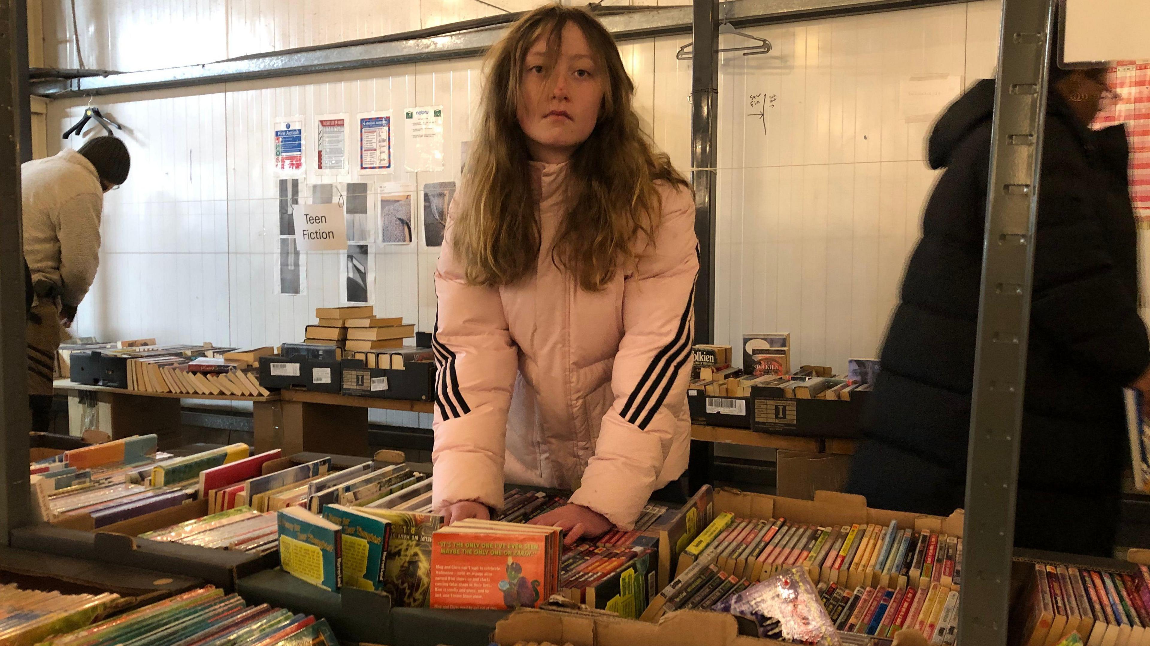 Kaya looking through a table full of books