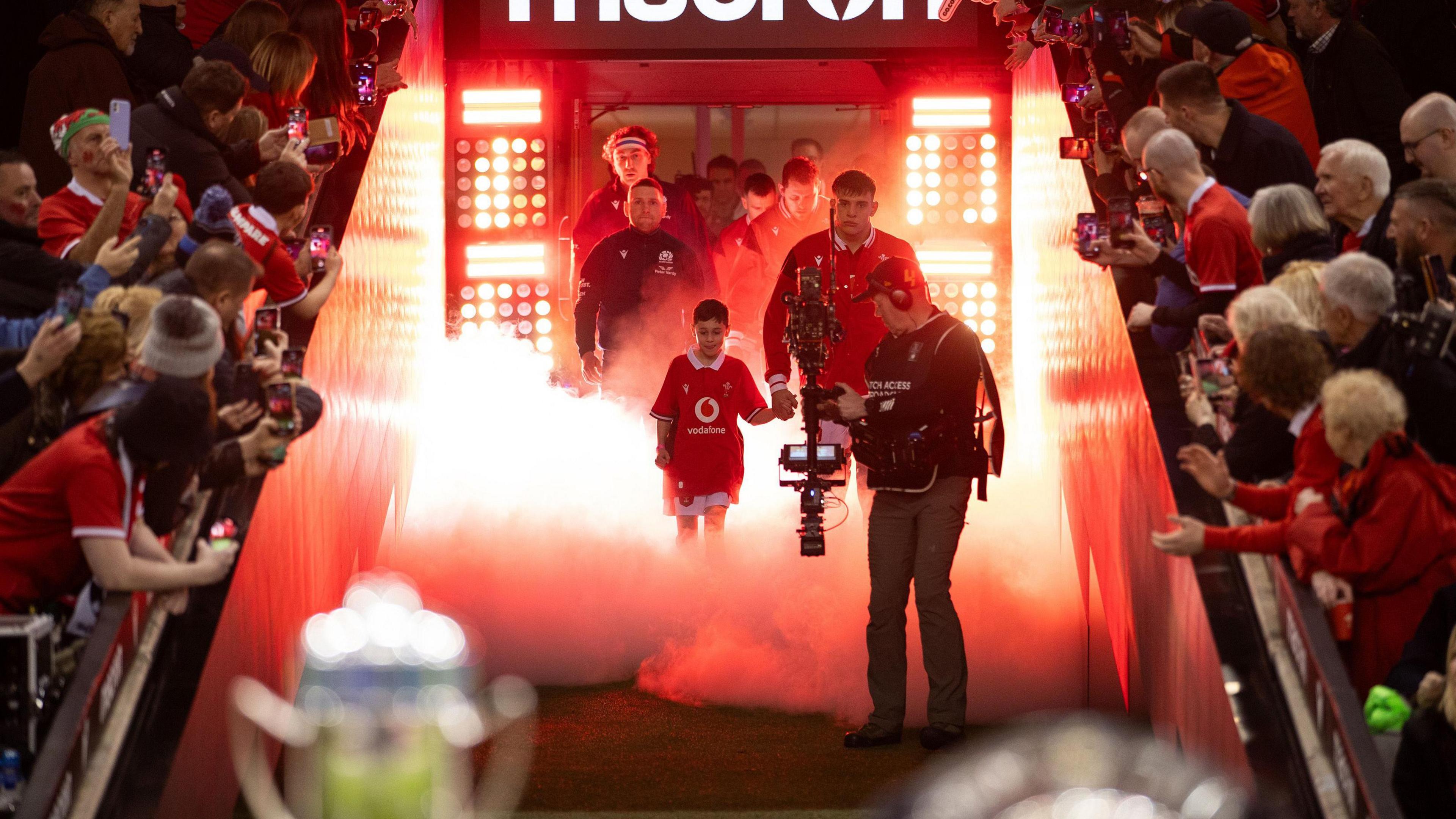 Dafydd Jenkins leads the Wales team onto the pitch against Scotland in February 2024