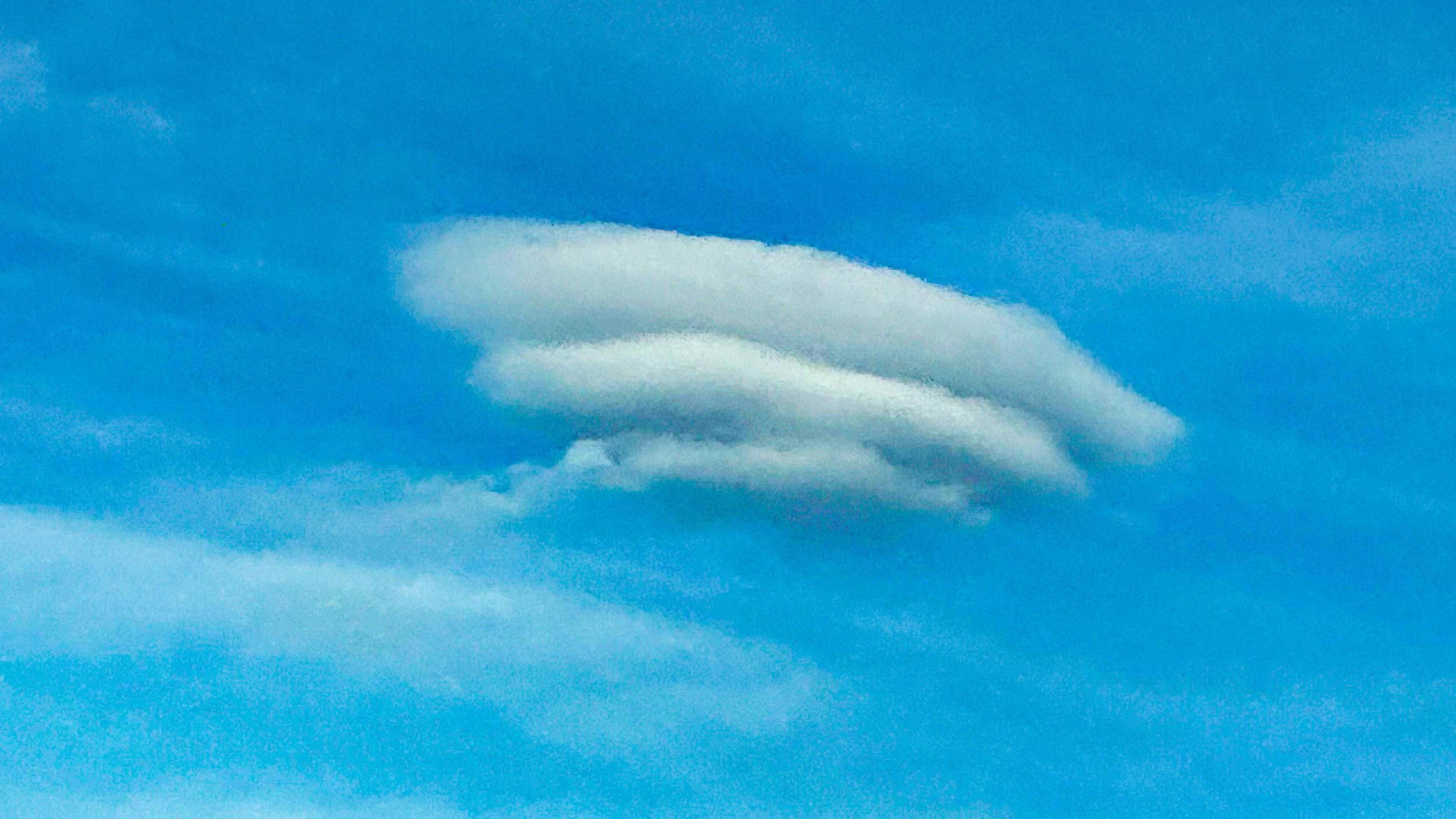 Blue sky with three lens-shaped clouds stacked on top of each other