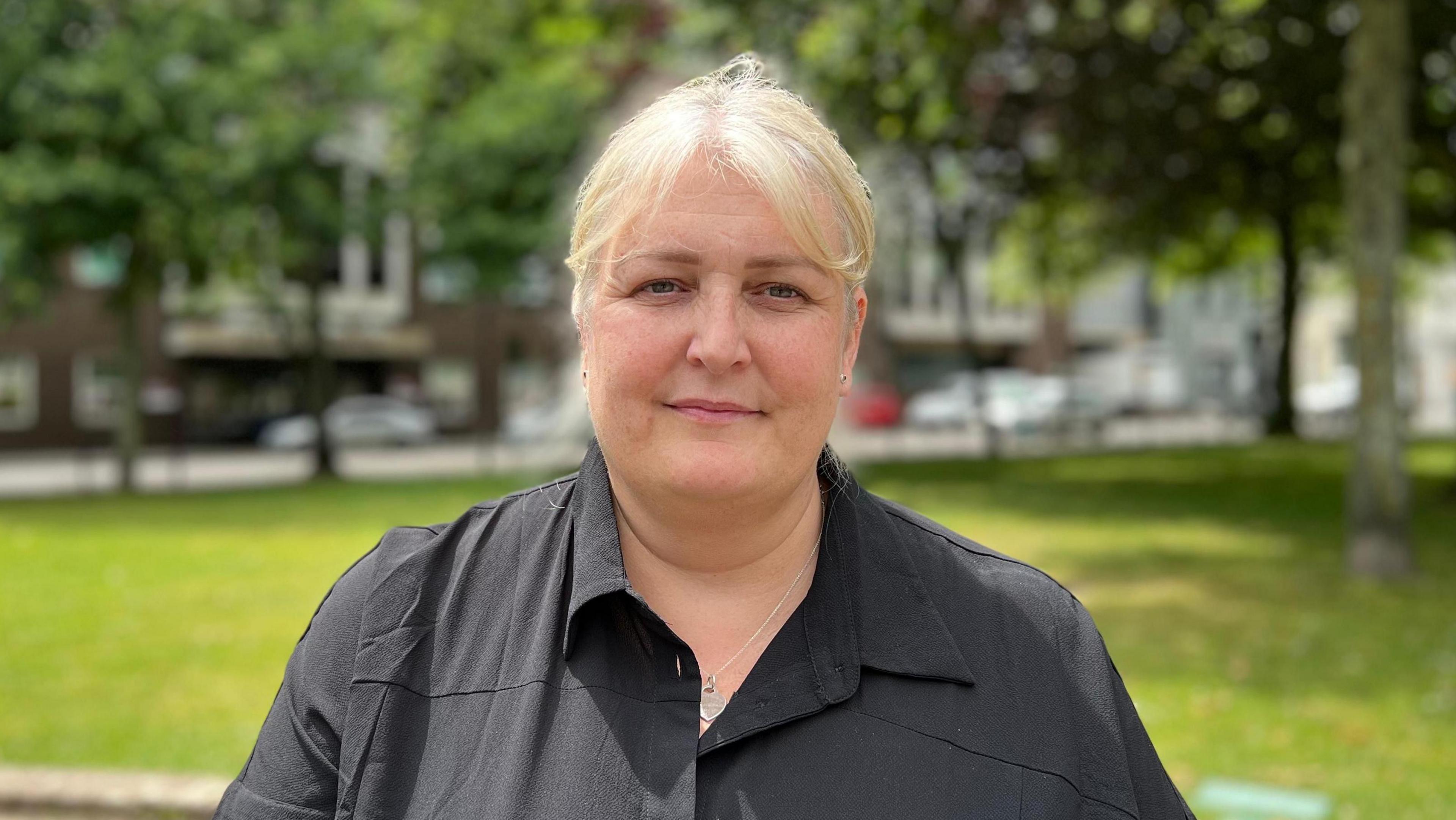 Roslyn Bullen-Bell staring at the camera in a park in front of the hospital