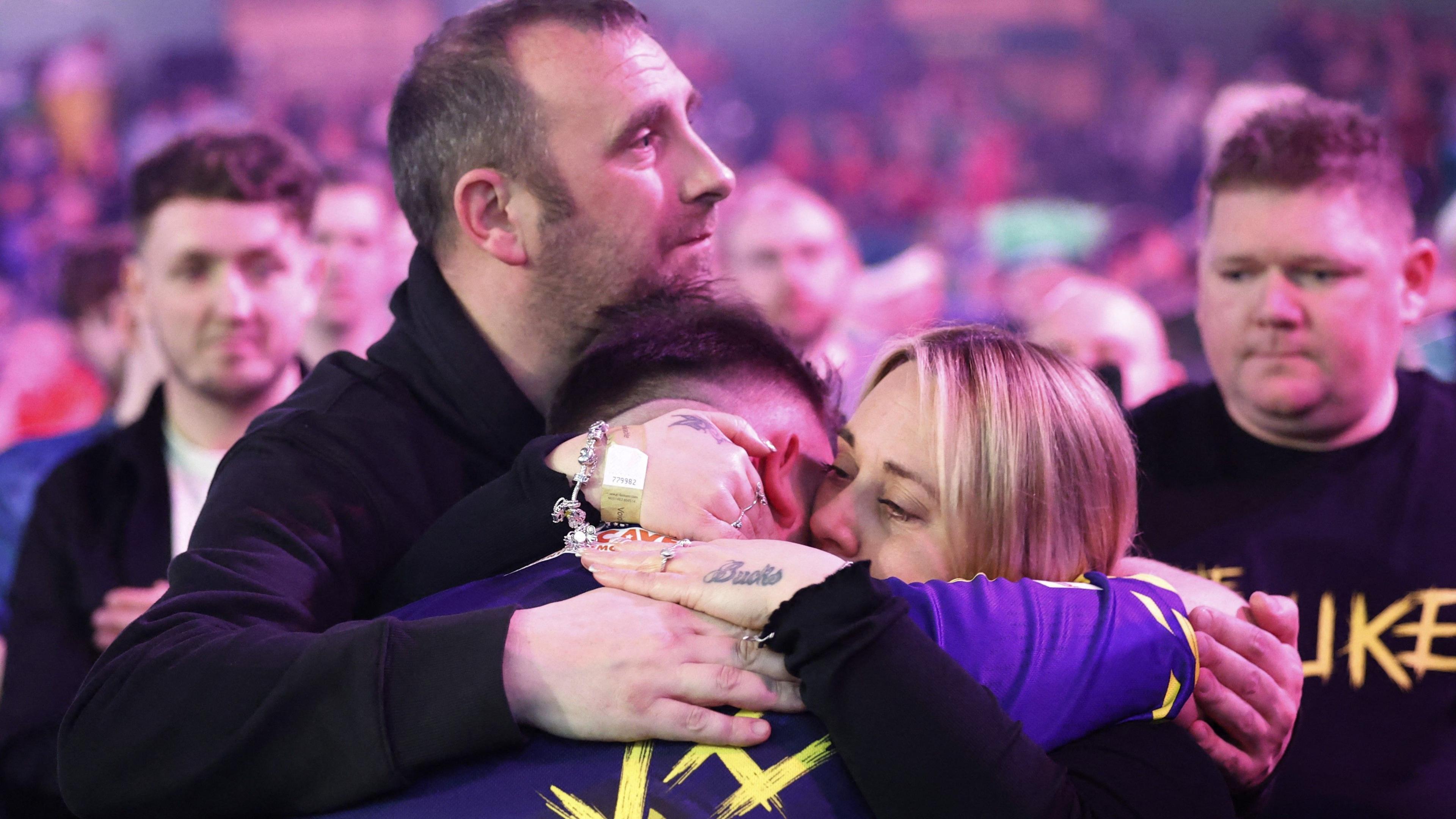 Luke Littler is hugged by his parents after beating Ryan Meikle