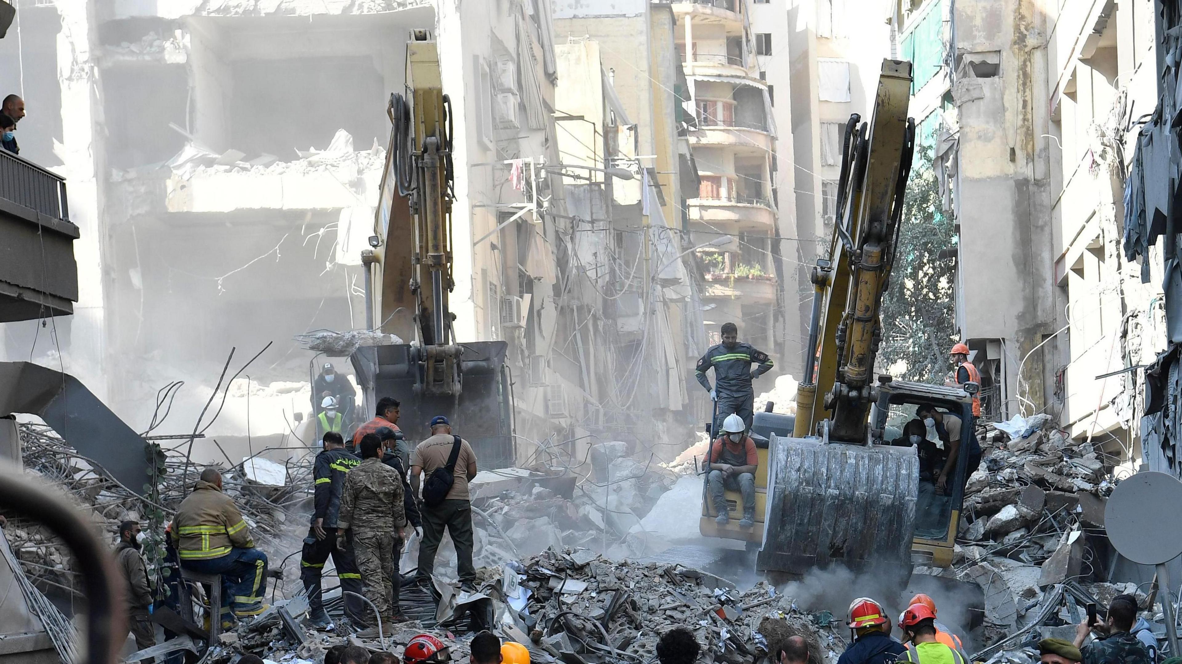 Workers and heavy machinery work through the rubble at the site of a massive Israeli airstrike in central London.