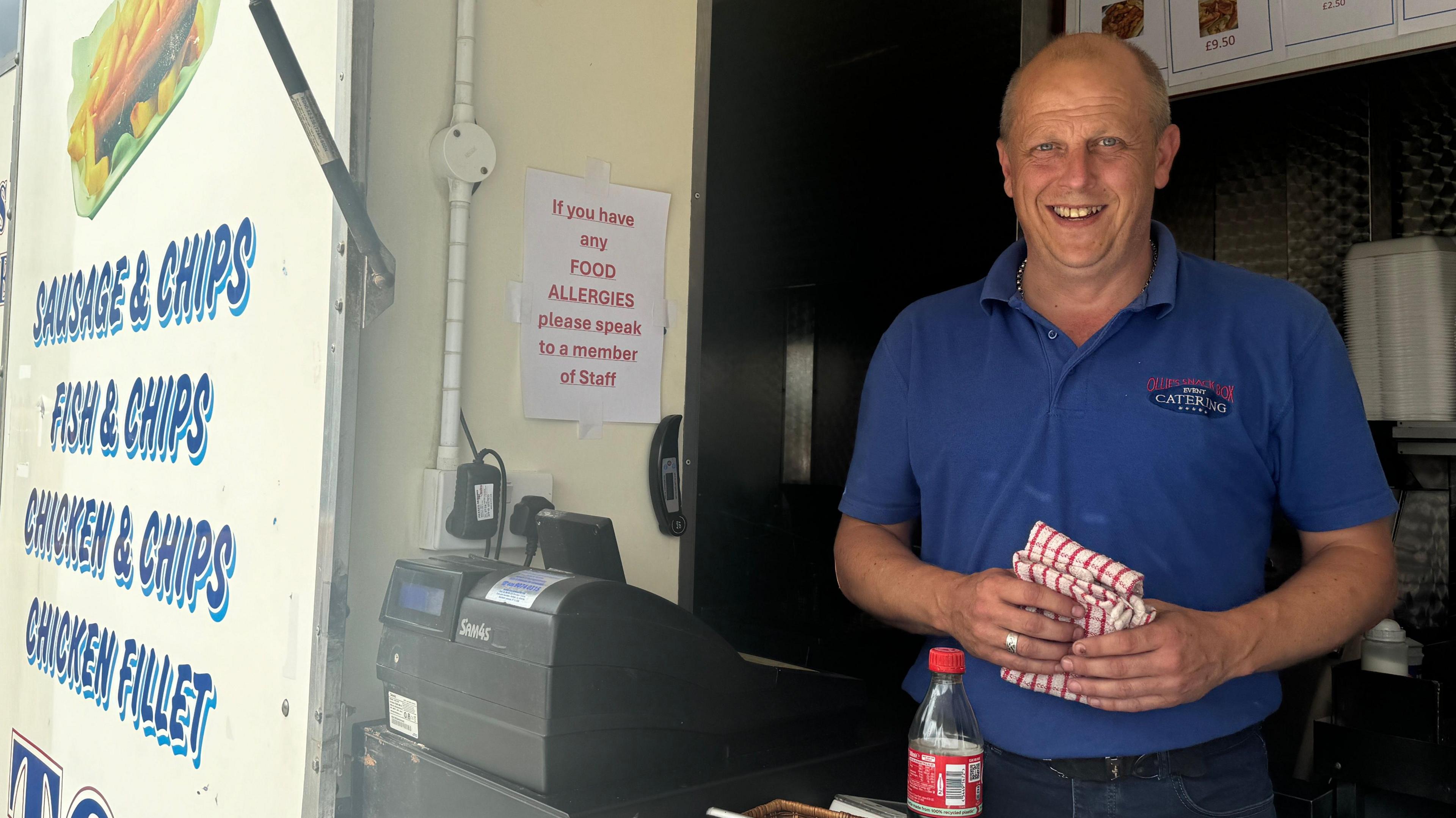 Chipvan owner standing at his till serving customers