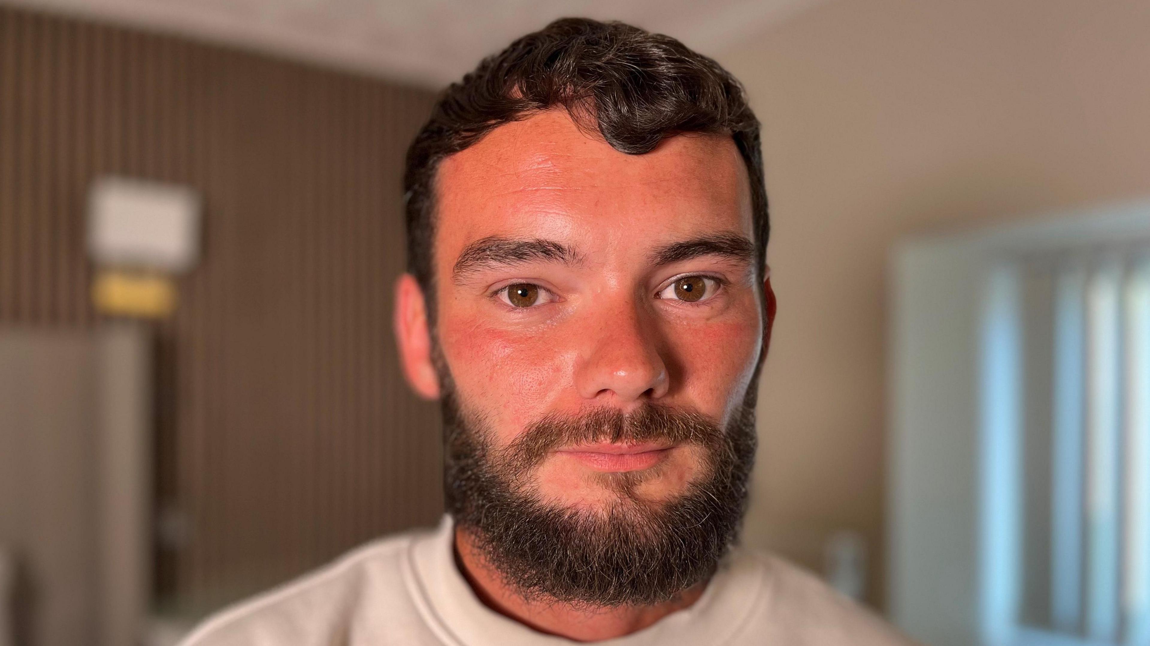 Will Griffiths has brown hair, eyes and a beard. He is looking directly at the camera
