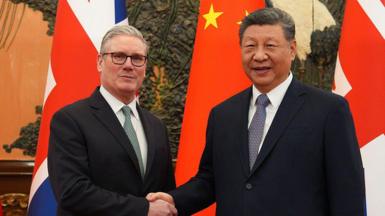 China's President Xi Jinping (R) and Britain's Prime Minister Keir Starmer shake hands before their meeting at the Great Hall of the People in Beijing on January 29, 2026.