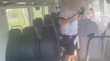 Man with face blurred and arms raised inside of train carriage