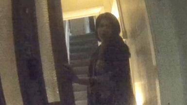 Woman opening a front door to a house