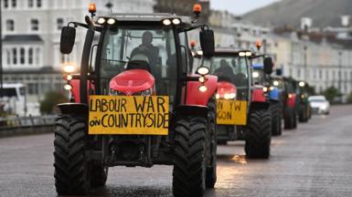 A tractor with red hub caps and a yellow sign saying "Labour War on Countryside". 