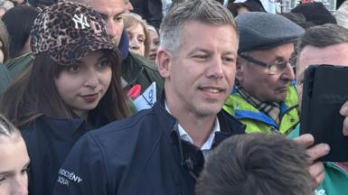 Man in blue surrounded by crowd