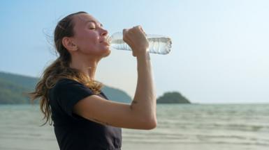 A woman drinks water in a stock image