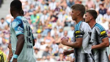 A general image showing Newcastle players and a Bayer Leverkusen player during their friendly match.