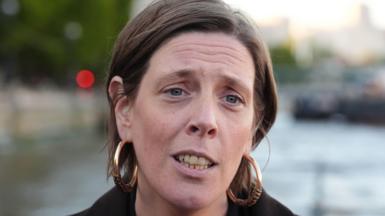 Jess Phillips has short brown hair tucked behind her ears. She is wearing a dark jacket and is forwards.