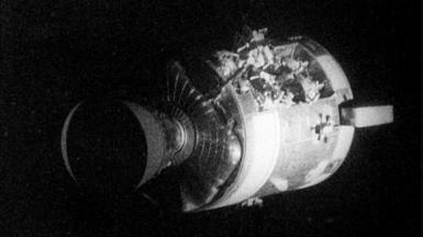 Apollo 13 service capsule is pictured with damage to its side.