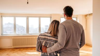 A couple looking across an empty room in a new house
