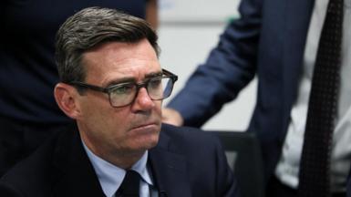 Burnham sitting down, wearing a blue suit