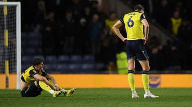 Oxford players Will Lankshear and Michal Helik look disconsolate following their defeat by Wrexham 