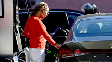 A woman pumps gas at an Exxon station in Washington, D.C. on April 7, 2026. 