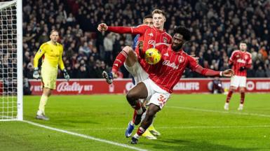 Nottingham Forest defender Ola Aina appears to control the ball with his arm inside the penalty area 