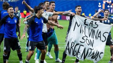 Argentina players holding a banner reading "Las Malvinas son Argentinas"