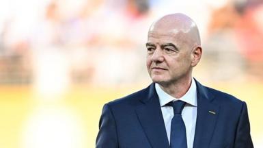 Gianni Infantino, wearing a dark suit and tie, looks to his right
