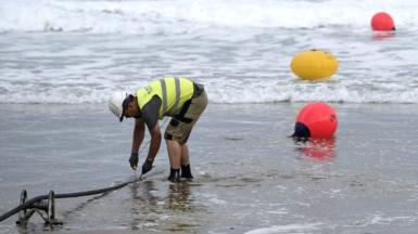 A technician works on a undersea fibre optic cable at Arrietara beach near the Spanish Basque village of Sopelana