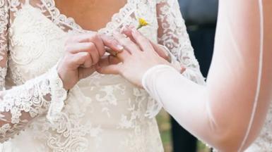 A ring is being placed on someone's finger at a wedding ceremony.