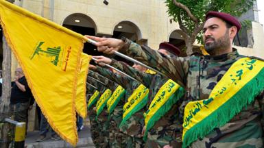 Hezbollah fighters taking the oath and raising flags 