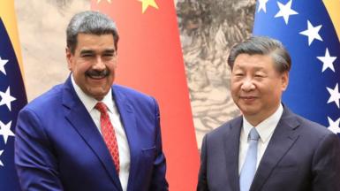 Venezuelan president Nicolás Maduro (L) and Chinese president Xi Jinping shake hands and smile in front of Venezuelan and Chinese flags at the palace in Beijing in 2023.