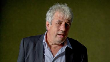 Rod Liddle looking up to his right, wearing a blue-striped shirt and navy jacket