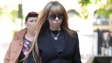 A woman with black glasses and brown hair. 