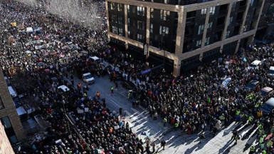 Thousands of protesters fill what can be seen from above of two wide city streets in downtown Minneapolis