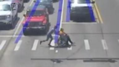 Man dressed as Spider-Man pushes wheelchair user across a crossing