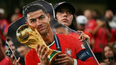 A Portugal fan holds a cardboard cutout of Cristiano Ronaldo with the World Cup trophy during the World Cup
