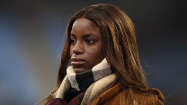 Eni Aluko stands pitchside during Aston Villa's Premier League match against Manchester City