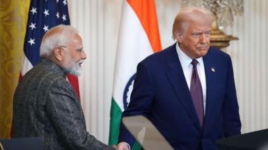 India Prime Minister Narendra Modi shakes hands with President Donald Trump at the White House in February during a press conference. Behind the two men are the flags of India and the US. Modi stands in profile while Trump is looking forward.