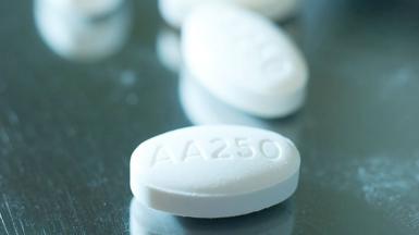 Close up of white, oval shape Abiraterone tablets, on a shiny, reflective table. 