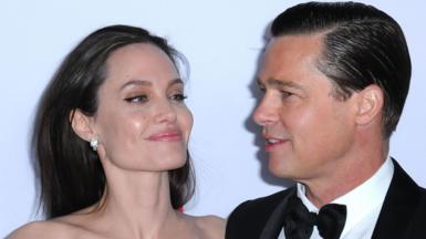 Angelina Jolie and Brad Pitt smile at each other on the red carpet at the gala premiere of By the Sea at 2015's AFI festival in Los Angeles