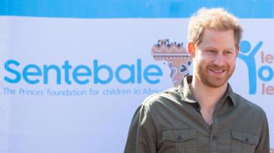Prince Harry with a banner of the Sentebale charity in 2019