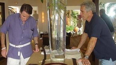 Peter Mandelson tries on a belt in a clothes shop as Jeffery Epstein looks on