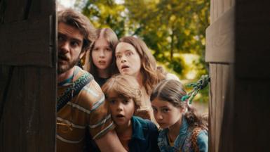 A family looks in awe through an open old door 
