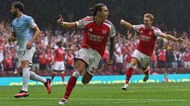 Riccardo Calafiori celebrates scoring for Arsenal with his finger raised in the air