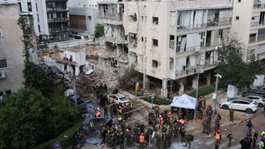 Aerial view of a damaged building surrounded by emergency services staff in Tel Aviv following strikes