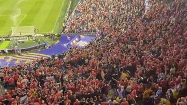 A crowd at Boston Stadium, with many thousands of Scotland fans in blue football strips and orange football strips.