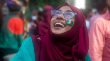 A Bangladeshi woman reacts on a street as people gather in Dhaka