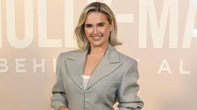 Molly-Mae Hague wearing a grey jacket on a pale pink background