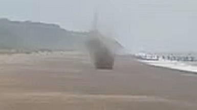 Mortar exploding on a beach.