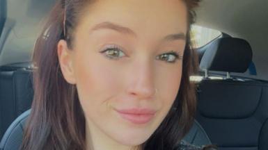 A close up photo of Rieve Nesbitt-Marr sitting in the back of a car and smiling at the camera.