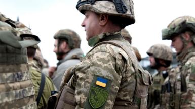 A soldier of the 423rd Separate Battalion of Unmanned Systems “Scythian Griffins” stands among other soldiers with a visible insignia patch of his battalion on October 10, 2025 in Zaporizhzhia Oblast, Ukraine.
