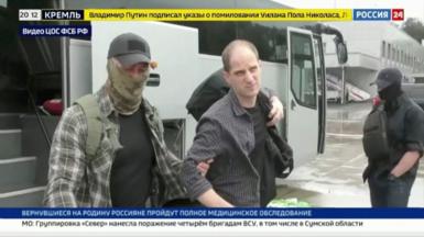 Russia TV clip showing Evan Gershkovich being escorted onto a plane